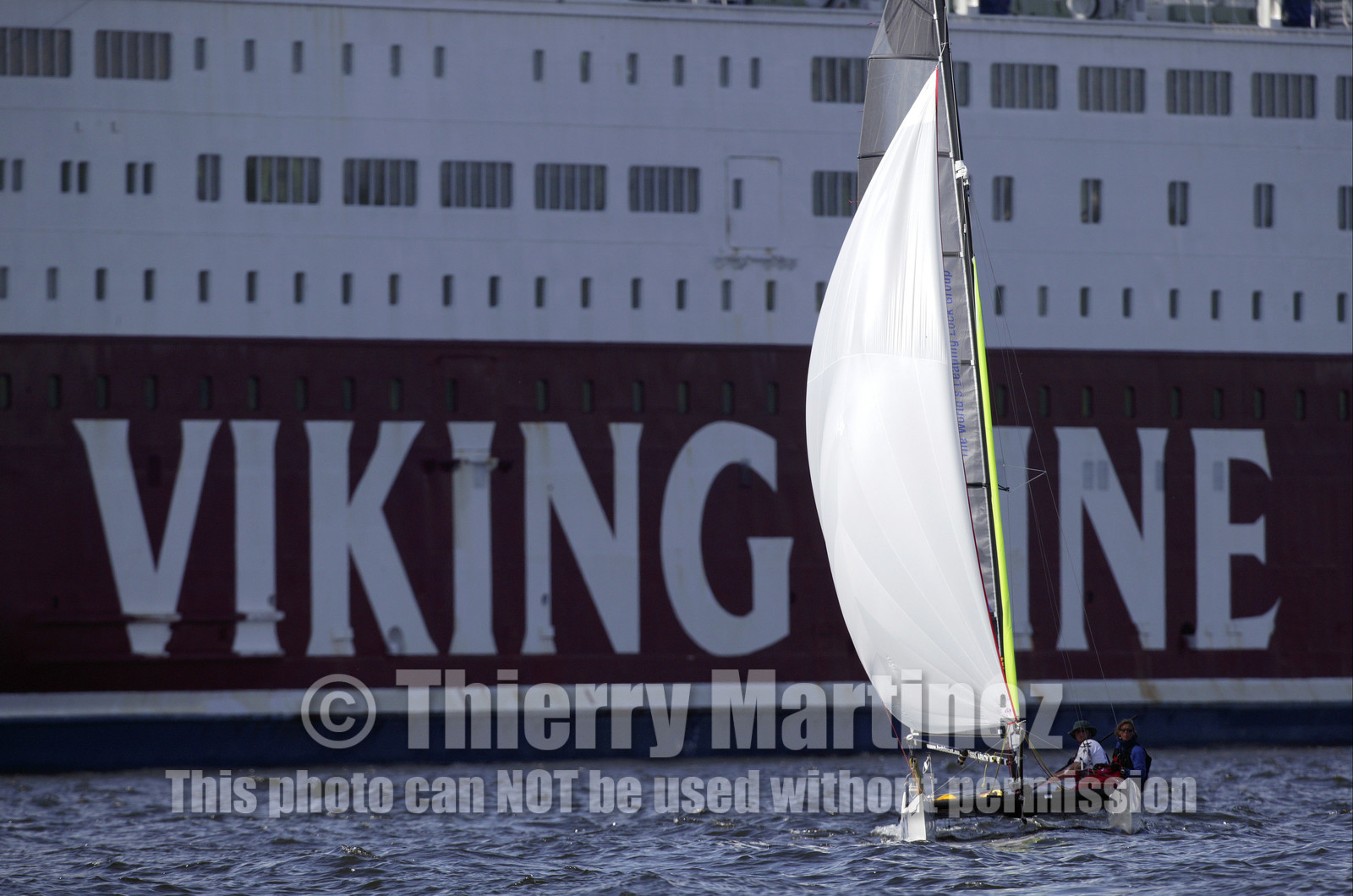 03_3272D © Th.Martinez,STOCKHOLM SWEDEN, 11 07 03-Archipelago Raid (2003) Day 4, last leg..ASSA ABLOY Neal and Lisa McDonald (UK) passing by a ferry in Sokholm harbour.