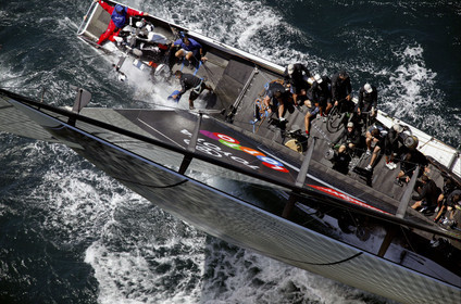 03_0169D ©Th.Martinez - Auckland (NZ) . America's Cup 2003. 15th February 2003. Day 1..Alinghi (SUI 64) vs Team NZ (NZL 82) .NZL 82 in first minutes of Race 1 before retiring on damage.  .Matt Mitchell (Team NZ midbowman) bailing water out of NZL 82. .