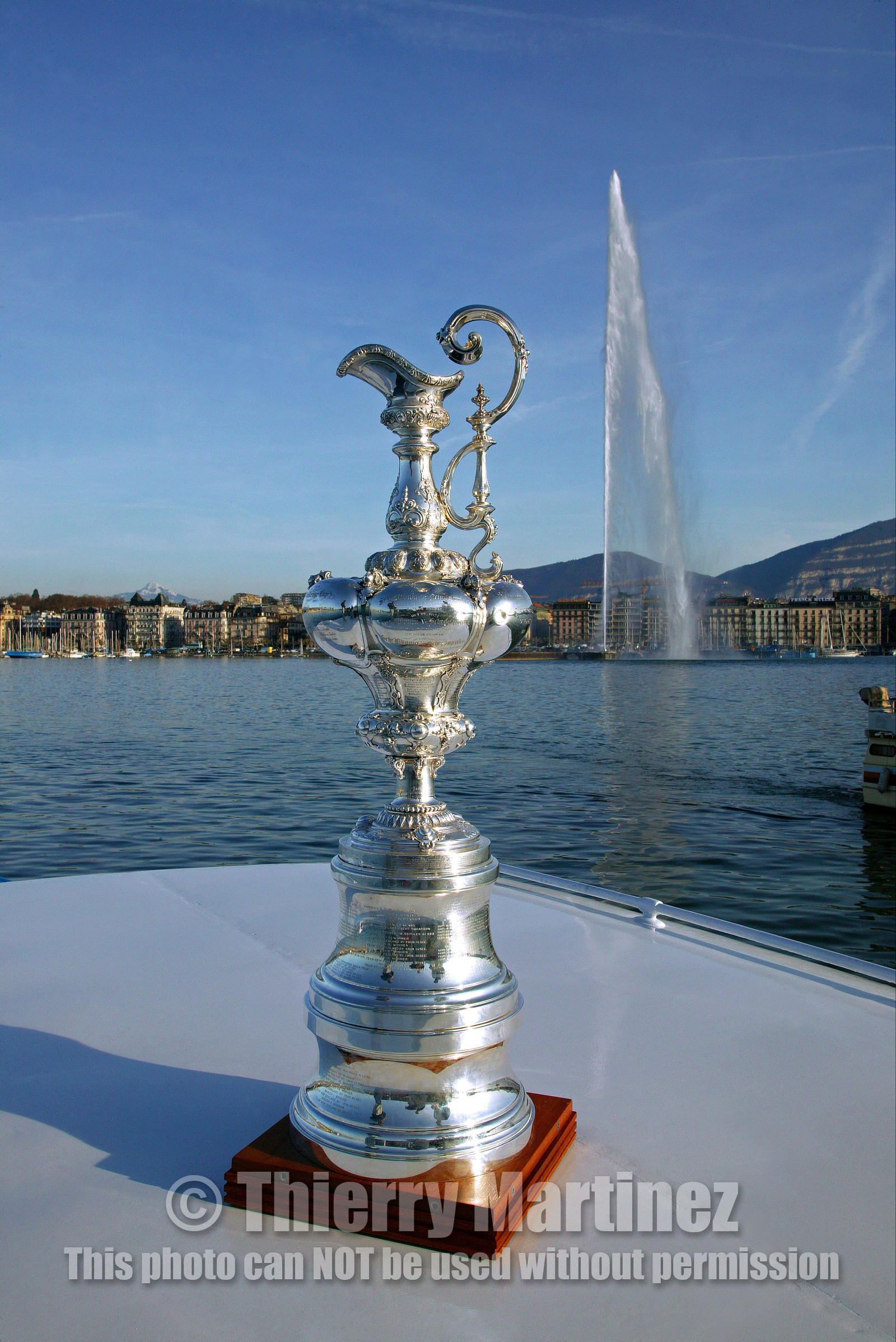 03_ 8600 ©Th.Martinez .Geneva , Switzerland. America's Cup 2003. 9th March 2003.Alinghi Team winner of America's Cup 2003..The America's Cup on the way to her new home, La Societe Nautique de Geneve (which is Alinghi Yacht Club). Alinghi Team and the CUP did a short trip by the Lac to arrive at La Nautique. On the way stop for a photo The Cup with jet deaude Geneve in the backgroung.